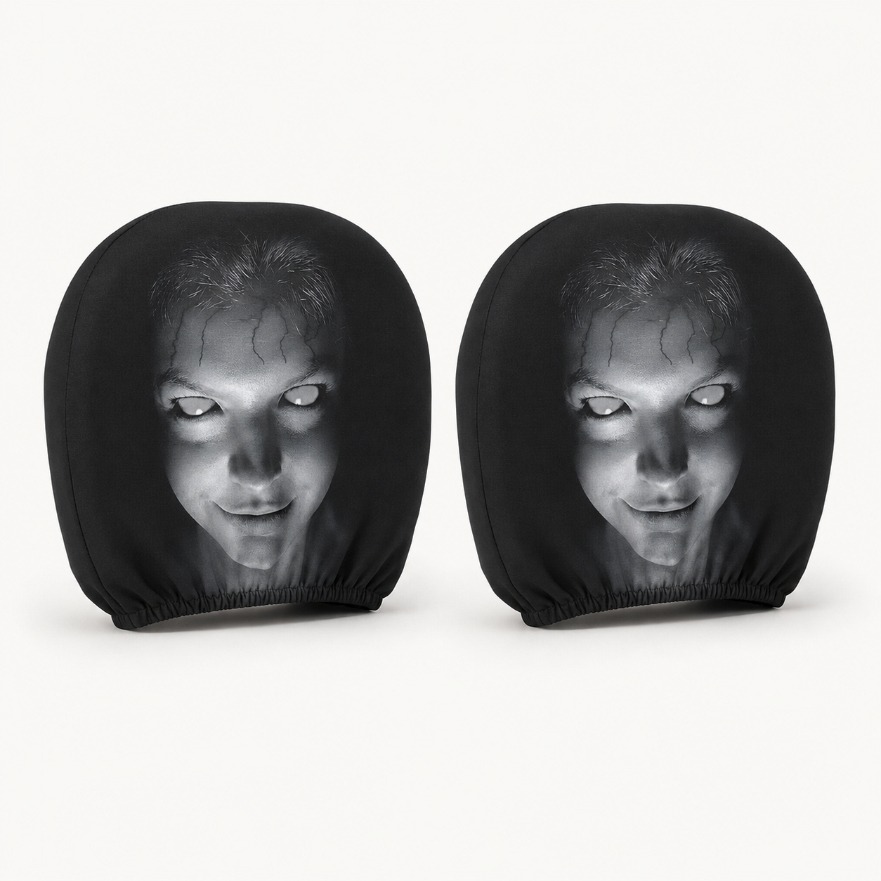 Two Pione ScareSeat black horror face car headrest covers on a warm white background
