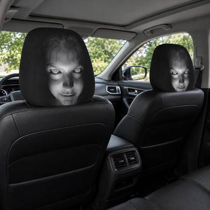 Two black horror face headrest covers installed on the front seats of a modern car